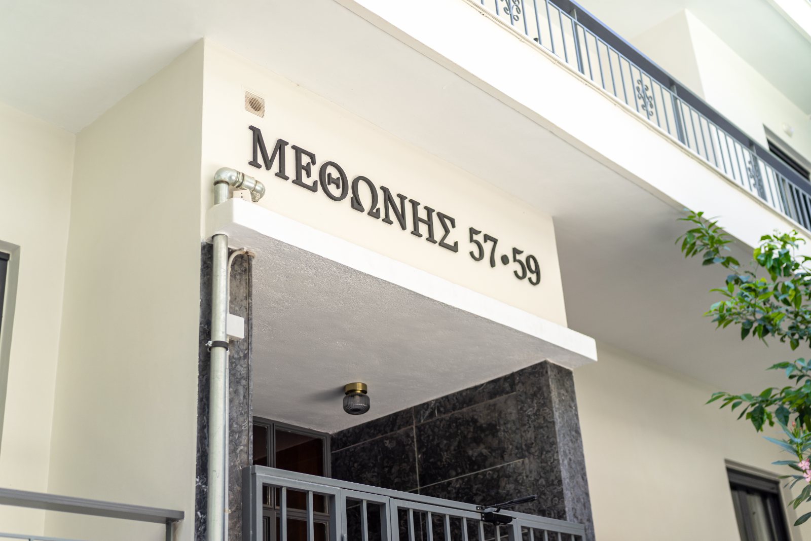 The building entrance in Exarchia, its number in gold lettering above the glazed door